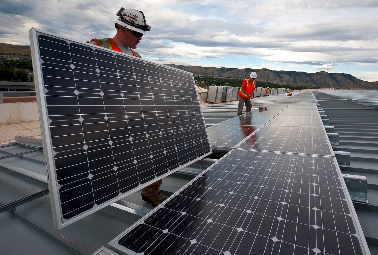 Arbeiter bauen Solarstromodule auf.